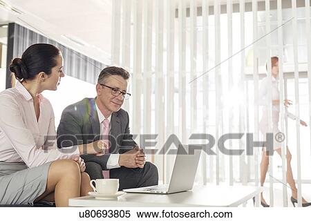 Businessman and businesswoman discussing in office View Large Photo Image Stock Photography - Businessman and businesswoman discussing in office. Fotosearch