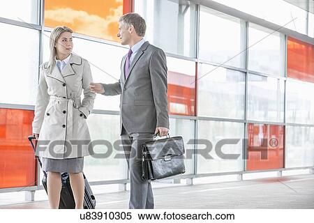 Businessman and businesswoman talking while walking on railroad platform View Large Photo Image Stock Photography - Businessman and businesswoman talking while walking on railroad platform. Fotosearch