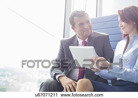 Businessman and businesswoman using tablet PC in office View Large Photo Image Stock Image - Businessman and businesswoman using tablet PC in office. Fotosearch