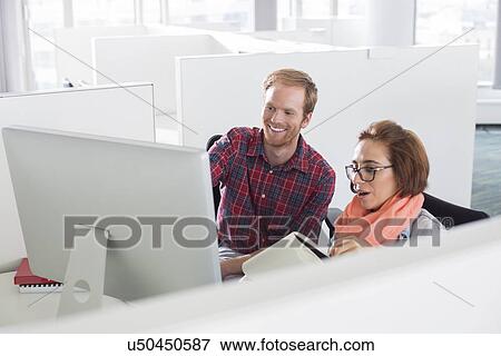 Businessman and businesswoman using computer in creative office View Large Photo Image Stock Photo - Businessman and businesswoman using computer in creative office. Fotosearch