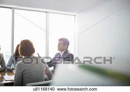 Businessman discussing with female team in conference room View Large Photo Image Stock Image - Businessman discussing with female team in conference room. Fotosearch