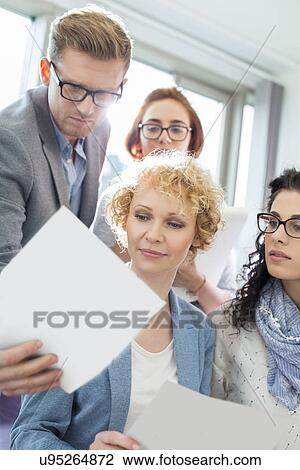 Businessman showing photograph to colleagues in creative focus View Large Photo Image Stock Image - Businessman showing photograph to colleagues in creative focus. Fotosearch