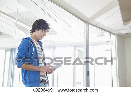 Businessman using tablet PC in creative office View Large Photo Image Stock Image - Businessman using tablet PC in creative office. Fotosearch