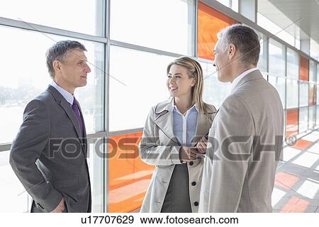 Stock Photo - Businesspeople communicating on train platform. Fotosearch