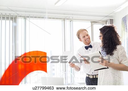 Businesspeople discussing in creative office View Large Photo Image Stock Image - Businesspeople discussing in creative office. Fotosearch