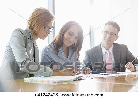 Stock Photograph - Businesspeople in meeting room. Fotosearch