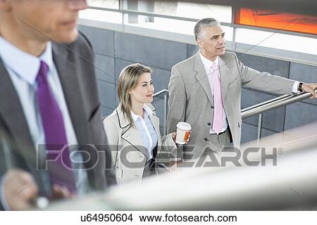 Picture - Businesspeople walking up stairs in train station. Fotosearch