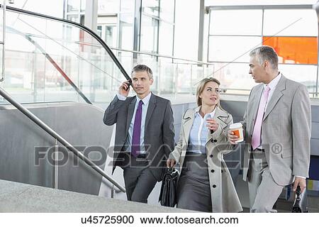 Businesspeople walking up stairs in train station View Large Photo Image Stock Image - Businesspeople walking up stairs in train station. Fotosearch