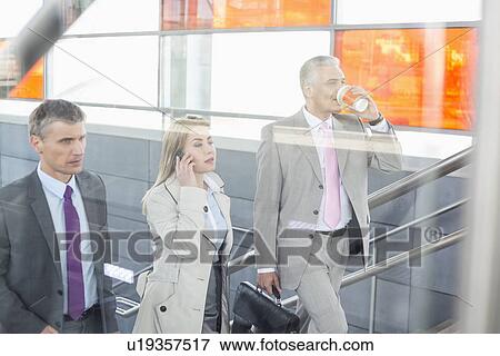 Businesspeople walking up stairs in train station View Large Photo Image Stock Photo - Businesspeople walking up stairs in train station. Fotosearch