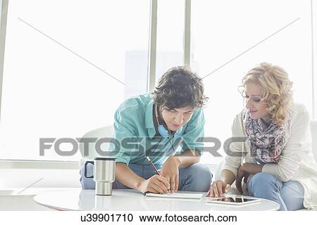 Businesspeople working at creative office lobby View Large Photo Image Stock Image - Businesspeople working at creative office lobby. Fotosearch