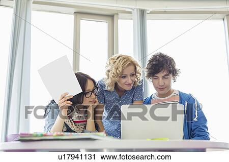 Businesspeople working in creative office View Large Photo Image Stock Image - Businesspeople working in creative office. Fotosearch