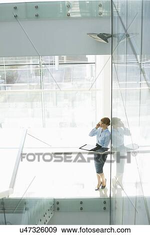 Businesswoman using cell phone in office View Large Photo Image Stock Photo - Businesswoman using cell phone in office. Fotosearch