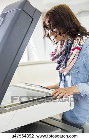 Businesswoman using photocopier in creative office View Large Photo Image Stock Image - Businesswoman using photocopier in creative office. Fotosearch