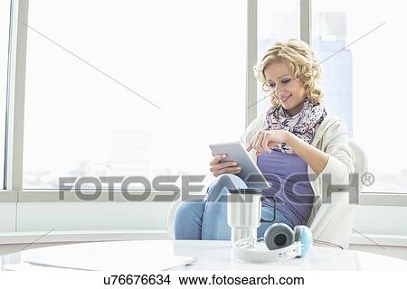 Businesswoman using tablet PC at creative office lobby View Large Photo Image Picture - Businesswoman using tablet PC at creative office lobby. Fotosearch