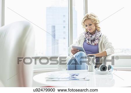 Businesswoman using tablet PC at creative office lobby View Large Photo Image Stock Image - Businesswoman using tablet PC at creative office lobby. Fotosearch