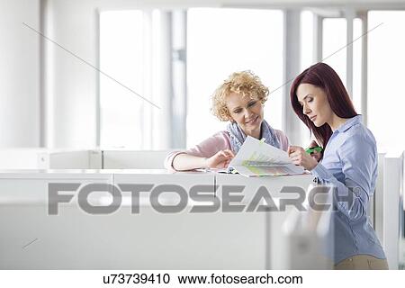 Businesswomen discussing in creative office View Large Photo Image Stock Image - Businesswomen discussing in creative office. Fotosearch