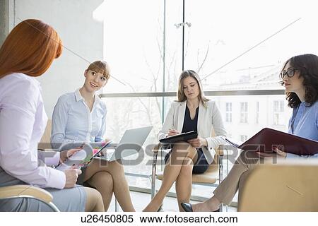 Stock Photography - Businesswomen discussing in office. Fotosearch