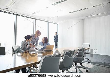 Businesswomen looking at documents in conference meeting View Large Photo Image Stock Photo - Businesswomen looking at documents in conference meeting. Fotosearch