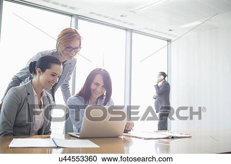 Businesswomen using laptop in office View Large Photo Image Stock Image - Businesswomen using laptop in office. Fotosearch