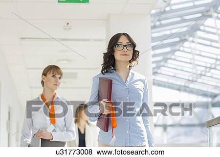 Businesswomen walking at office View Large Photo Image Stock Photo - Businesswomen walking at office. Fotosearch