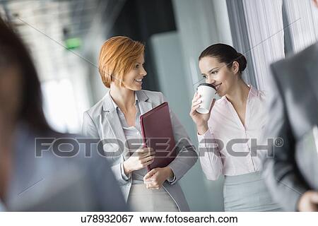 Businesswomen walking in office corridor View Large Photo Image Stock Photo - Businesswomen walking in office corridor. Fotosearch