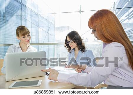 Businesswomen working at table in office View Large Photo Image Stock Image - Businesswomen working at table in office. Fotosearch