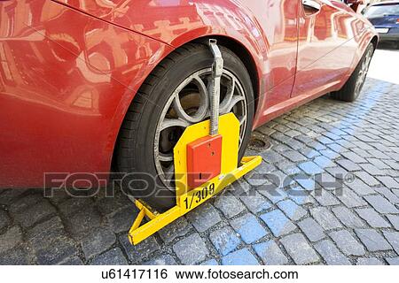 Stock Photograph - Car clamped on cobbled street. Fotosearch