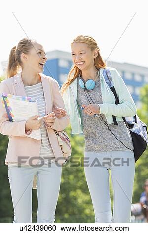 Cheerful young female college students walking in campus View Large Photo Image Stock Image - Cheerful young female college students walking in campus. Fotosearch