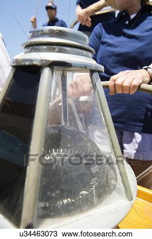 Stock Image - Close-up of compass on sailboat's helm. Fotosearch