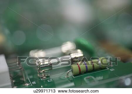 Stock Image - Close-up of fuse and resistor on circuit board. Fotosearch