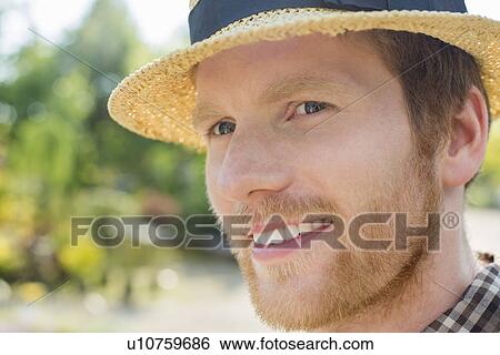 Stock Photograph - Close-up of gardener smiling while looking away. Fotosearch