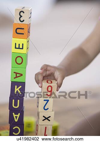 Stock Image - Close-up of girl playing with blocks at home. Fotosearch