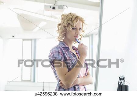 Concentrated businesswoman looking at presentation board in creative office View Large Photo Image Stock Photo - Concentrated businesswoman looking at presentation board in creative office. Fotosearch