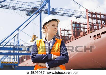 Stock Photo - Confident female engineer in shipping yard. Fotosearch