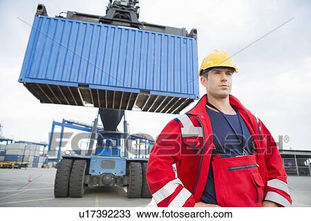 Confident male worker standing in front of freight vehicle at shipyard View Large Photo Image Stock Image - Confident male worker standing in front of freight vehicle at shipyard. Fotosearch