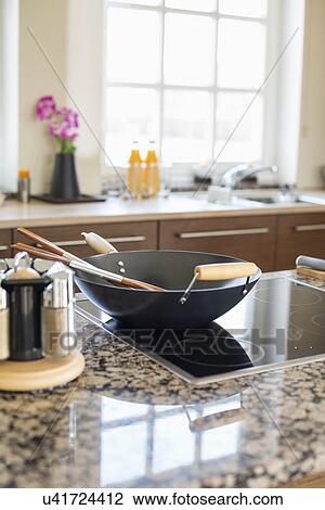 Stock Image - Cooking utensils on stove in kitchen. Fotosearch