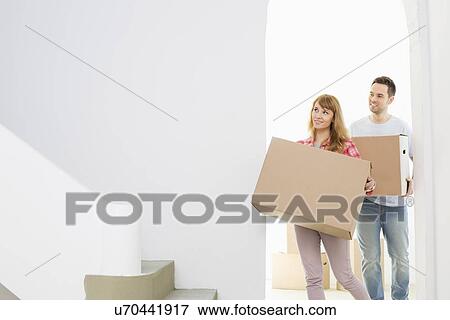 Couple carrying moving boxes View Large Photo Image Stock Photo - Couple carrying moving boxes. Fotosearch