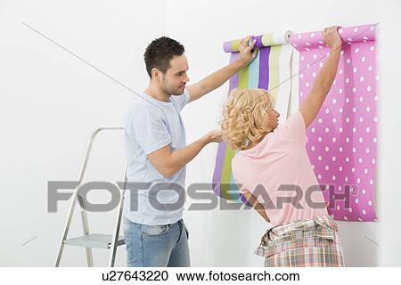 Couple holding up wallpaper samples in new house View Large Photo Image Stock Image - Couple holding up wallpaper samples in new house. Fotosearch