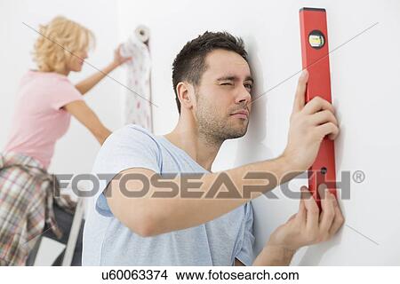 Couple working together in new house View Large Photo Image Picture - Couple working together in new house. Fotosearch