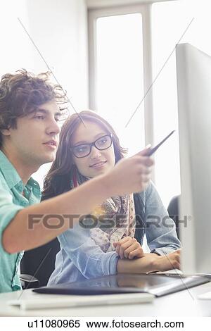 Creative business colleagues discussing over desktop computer in office View Large Photo Image Stock Photography - Creative business colleagues discussing over desktop computer in office. Fotosearch