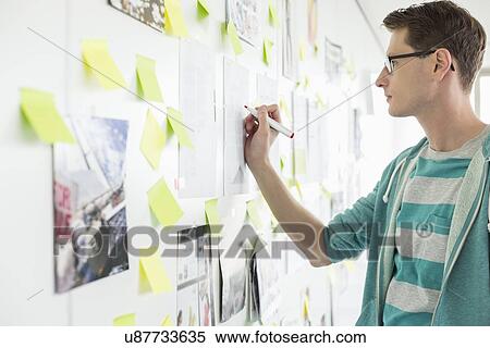 Creative businessman writing on paper in office View Large Photo Image Stock Photography - Creative businessman writing on paper in office. Fotosearch