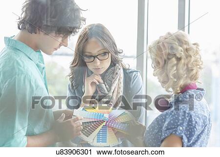 Creative businesspeople analyzing color swatches in office View Large Photo Image Stock Image - Creative businesspeople analyzing color swatches in office. Fotosearch