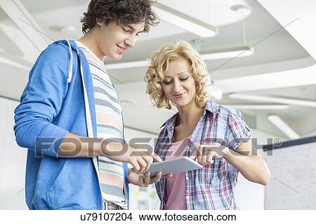 Creative businesspeople using digital tablet together in office View Large Photo Image Picture - Creative businesspeople using digital tablet together in office. Fotosearch
