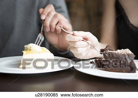 Stock Photography - Cropped image of couple having pastries. Fotosearch
