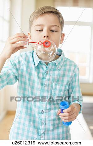 Cute boy playing with bubble wand at home View Large Photo Image Stock Photo - Cute boy playing with bubble wand at home. Fotosearch