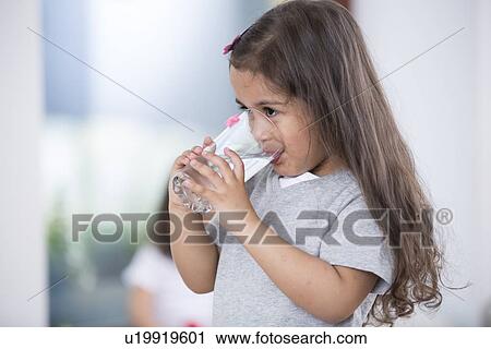 Cute girl drinking glass of water at home View Large Photo Image Stock Image - Cute girl drinking glass of water at home. Fotosearch