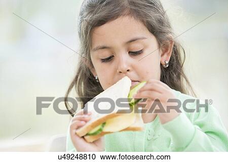 Cute girl eating sandwich at home View Large Photo Image Stock Image - Cute girl eating sandwich at home. Fotosearch
