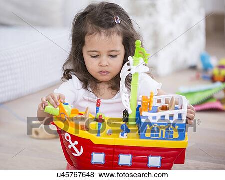 Cute girl playing with toy ship at home View Large Photo Image Stock Photo - Cute girl playing with toy ship at home. Fotosearch