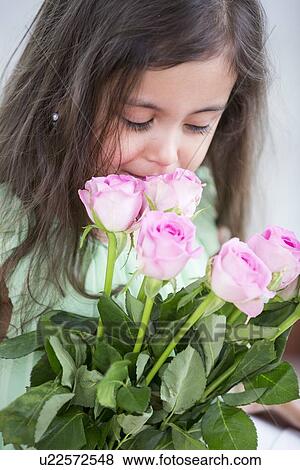 Cute girl smelling roses at home View Large Photo Image Stock Photo - Cute girl smelling roses at home. Fotosearch