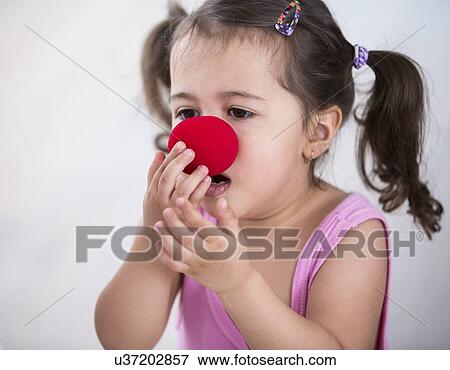 Cute girl wearing clown nose at home View Large Photo Image Stock Photo - Cute girl wearing clown nose at home. Fotosearch